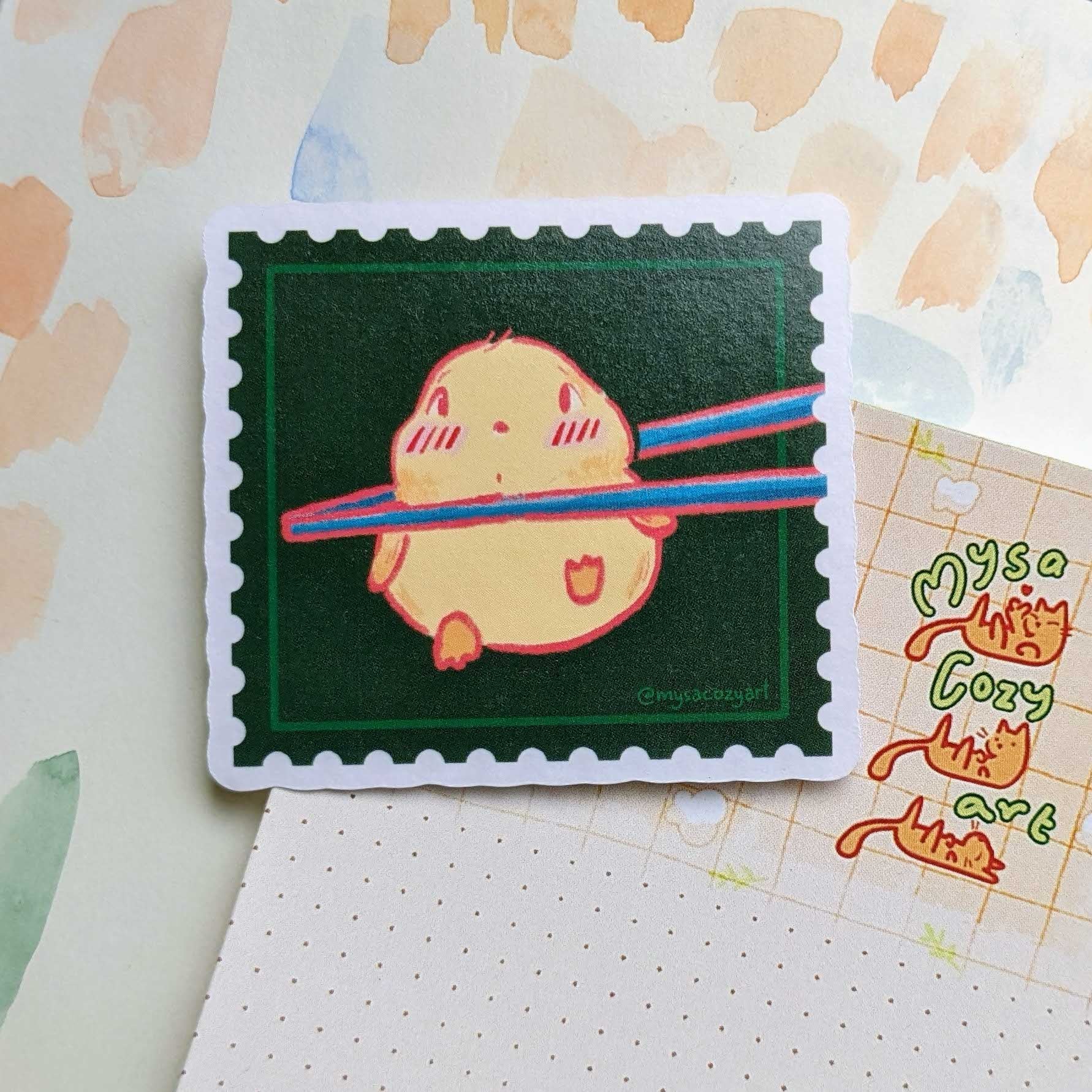Die-cut vinyl cute sticker of a round yellow chick being held up by wooden chopsticks, cute food-themed illustration.