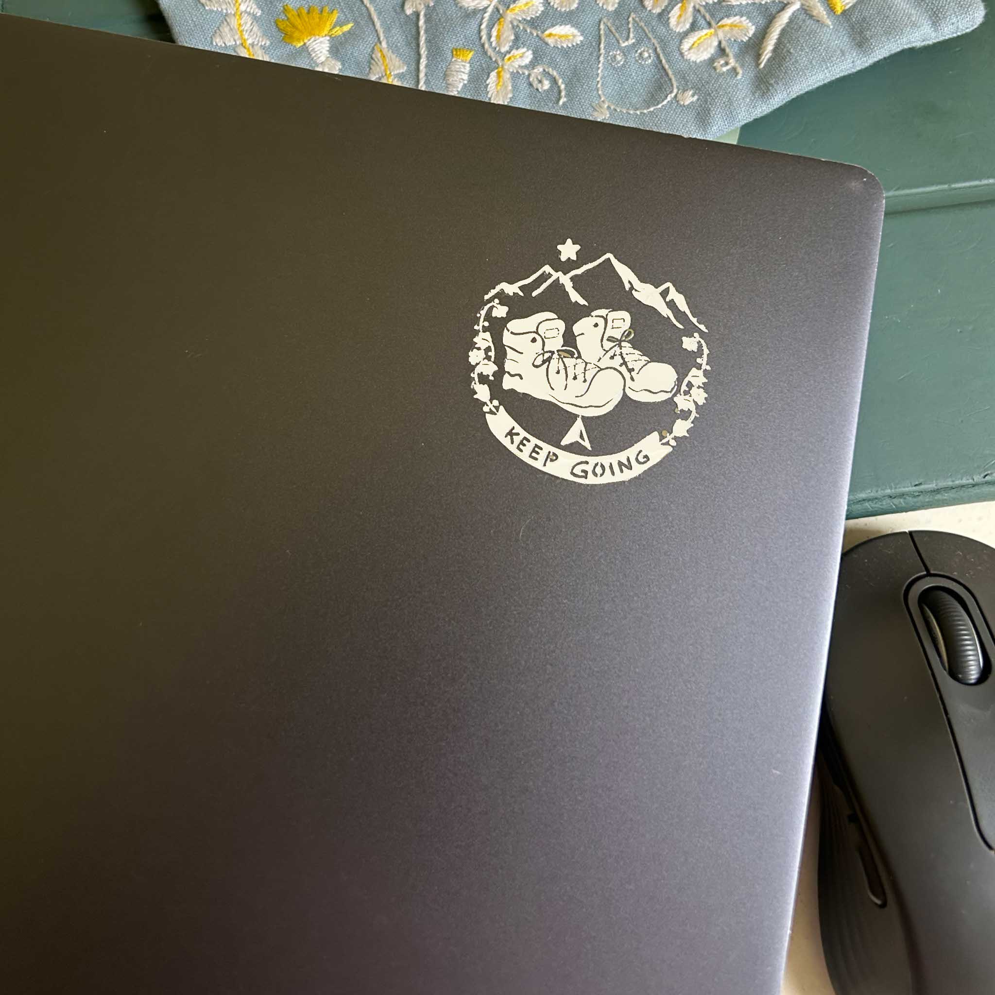 A premium silver metallic Travel sticker featuring cozy hiking boots and mountains. Raised 3D texture, waterproof, and perfect for wanderers. 